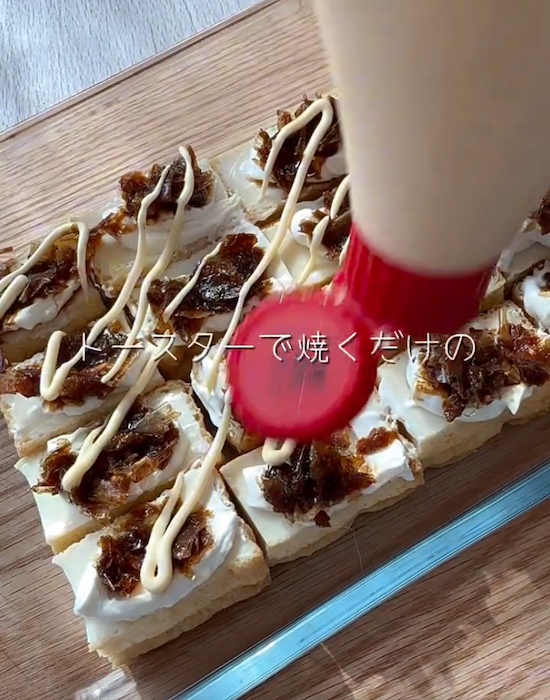 クリームチーズとカツオ節をかけた厚揚げの上にマヨネーズをかける様子