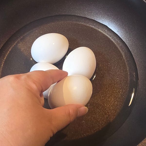 水を入れたフライパンに卵を入れる様子