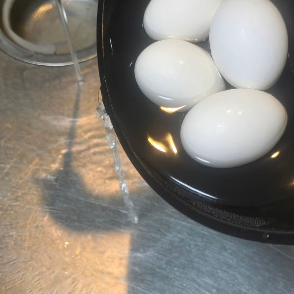 フライパンのお湯をシンクに捨てる様子