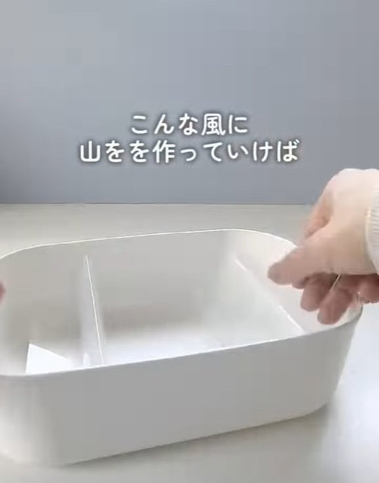 クリアファイルで作った仕切りをボックスに入れている様子