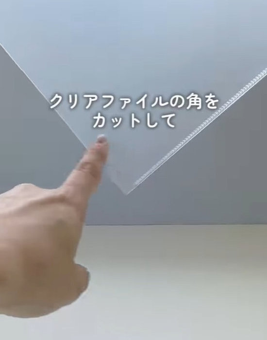 クリアファイルの角を指差す人