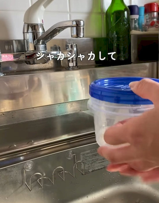 蓋をした保存容器を手にしている様子