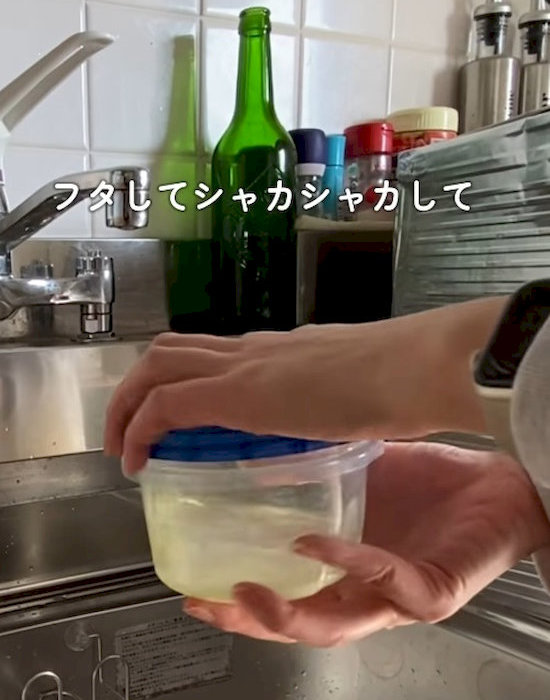蓋をした保存容器を振る様子