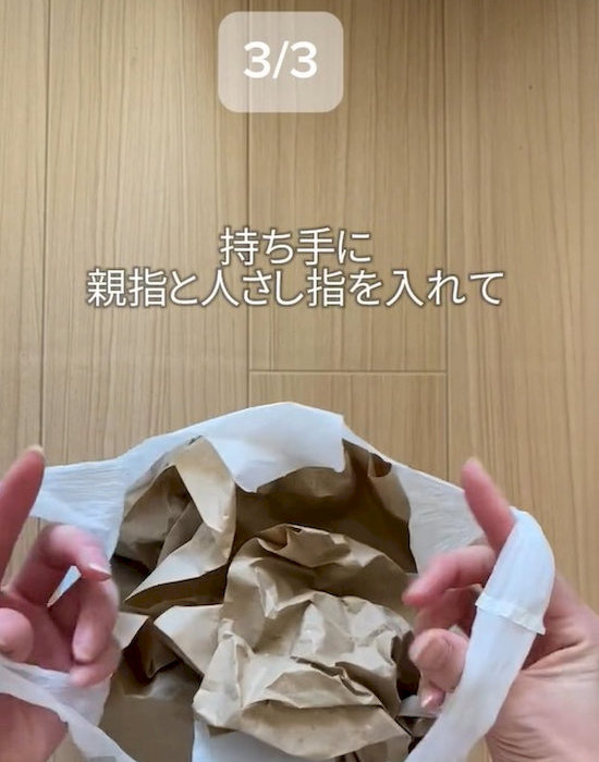 ビニール袋の持ち手に親指と人さし指を入れている様子