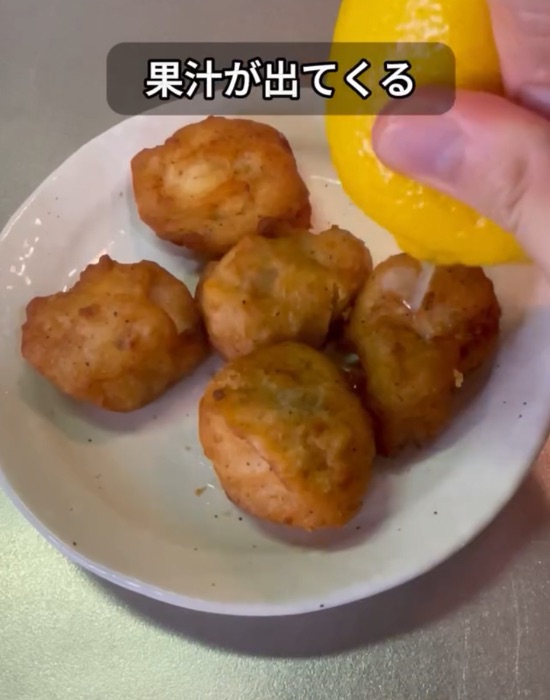から揚げにレモン果汁を絞る様子