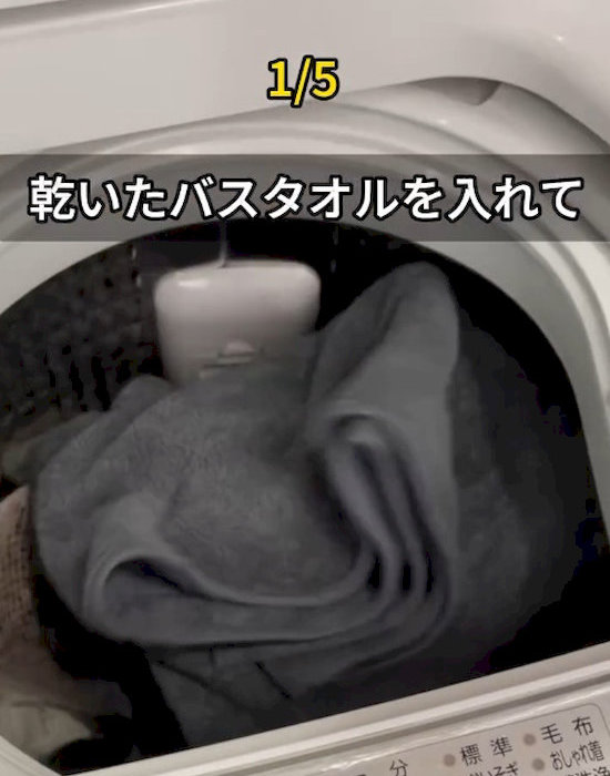 洗濯機の中にバスタオルを入れている様子