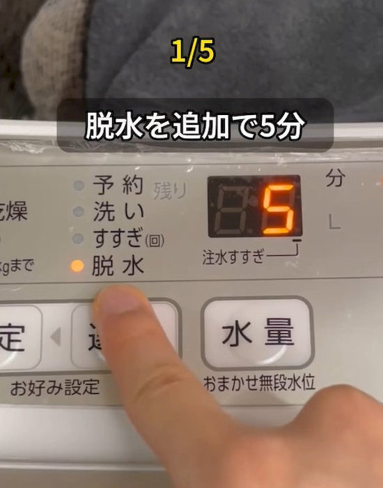 洗濯機のパネルを操作している様子