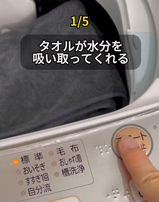 洗濯機のボタンを押している人