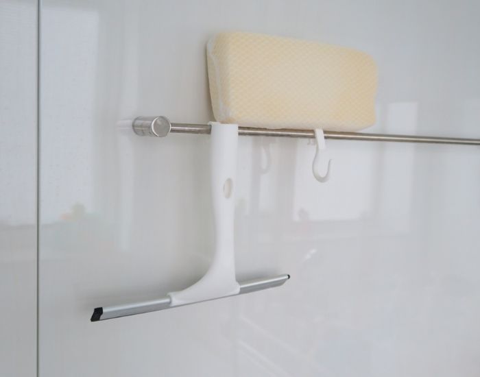 浴室内のタオルバーに掃除用具をかけている様子