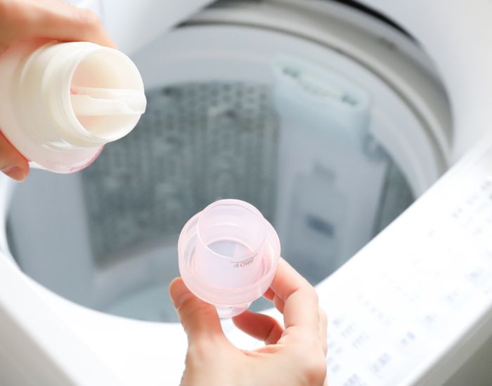 洗濯洗剤のキャップに洗剤を注ごうとしている様子