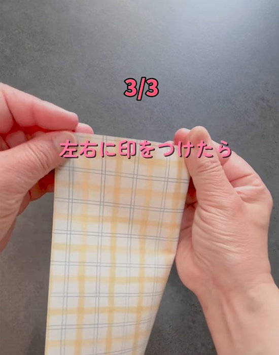 筒状にしたA４サイズの紙に印を付けている様子