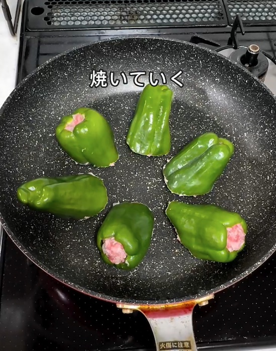 フライパンで肉詰めピーマンを焼く様子