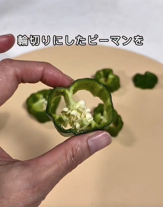 輪切りにしたピーマンを手にしている様子