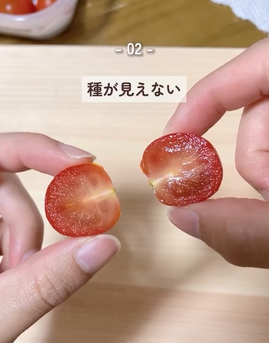 半分に切ったミニトマトを手にしている様子