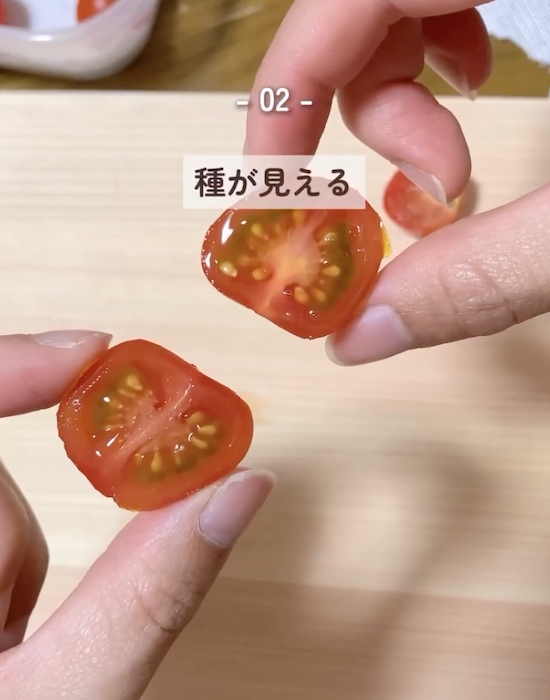 半分に切ったミニトマトを手にしている様子