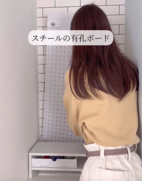 有孔ボードを手にしている女性
