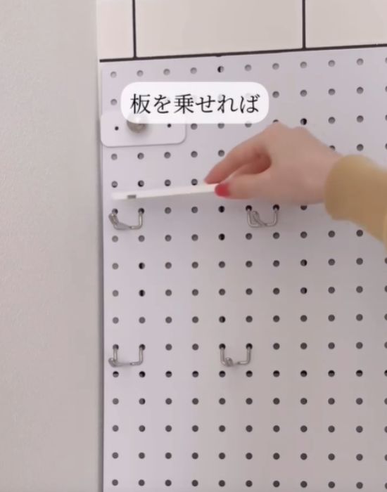 有孔ボードにフックをかけ、木材をのせる様子