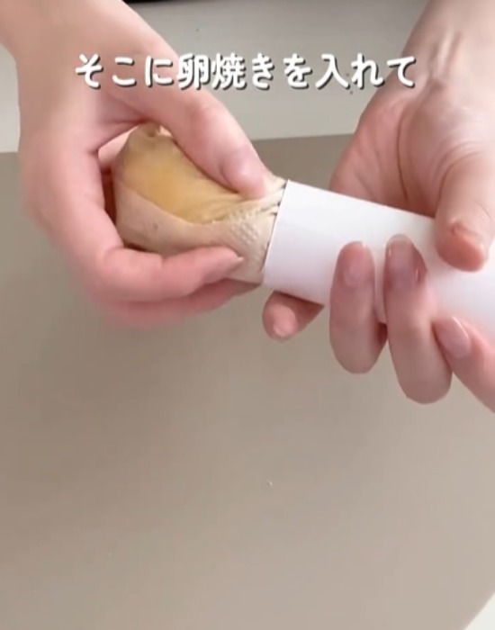 加熱した卵をキッチンペーパーの芯に入れている様子