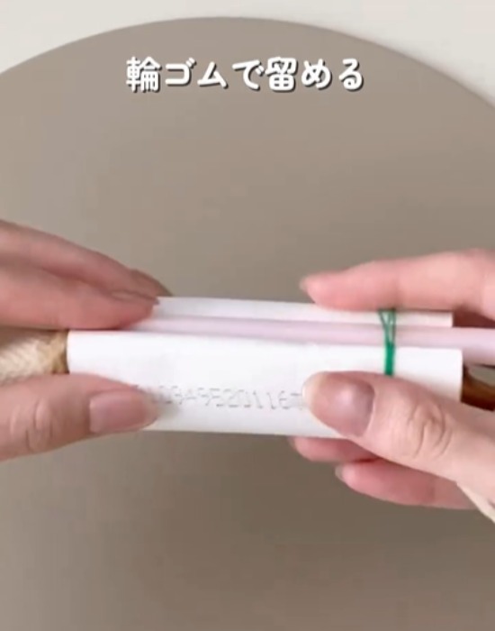 卵をキッチンペーパーの芯とストローと輪ゴムで固定している様子