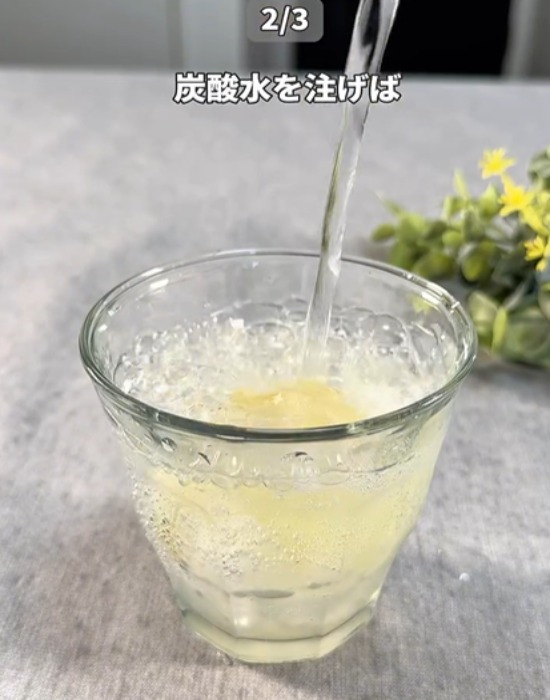 サクレレモンとハチミツが入ったコップに炭酸水を入れている様子