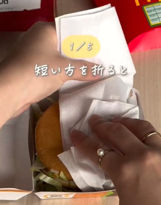紙ナプキンを折ってハンバーガーを包む様子