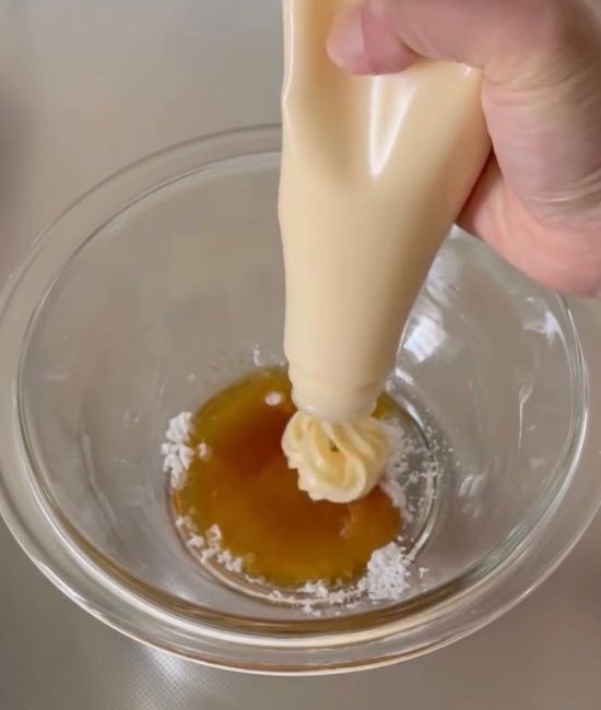 ボウルにマヨネーズなどの調味料を入れる様子