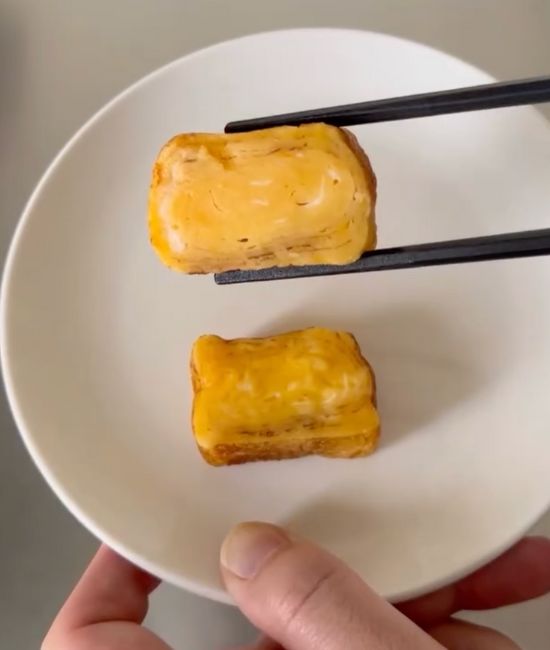 解凍した卵焼きを箸でつまみ上げた様子
