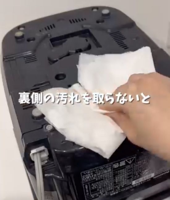 炊飯器の底面に付いたホコリを雑巾で拭きとる様子