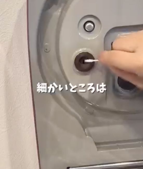 内蓋の裏側に付いた汚れを綿棒で取り除く様子