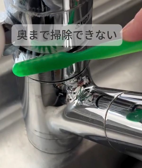 蛇口の溝を歯ブラシで掃除する様子