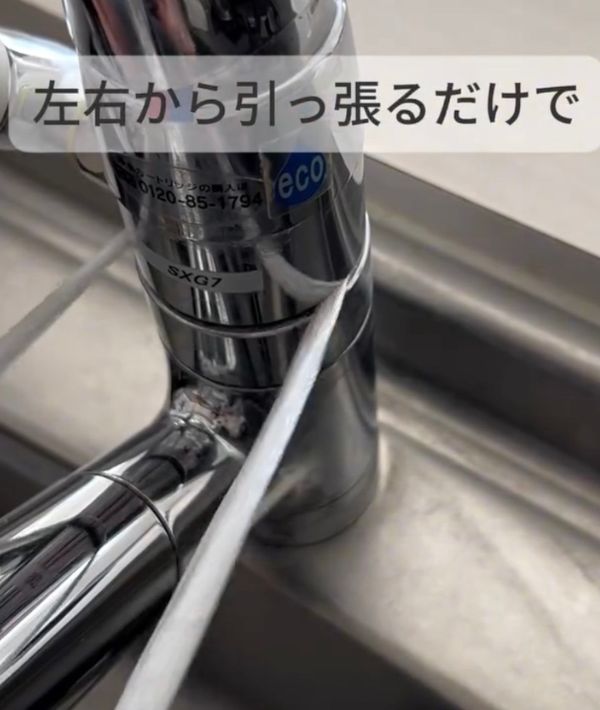 蛇口の溝に引っかけたビニール紐を左右から引っ張る様子
