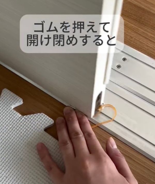 レールの上に置いた輪ゴムを手で押さえながら引き戸を閉める様子