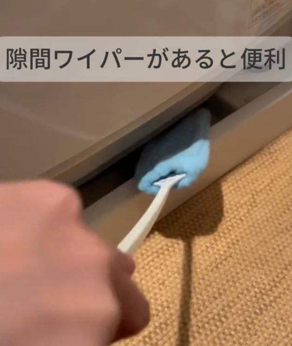 洗濯機の下に『隙間ワイパー』を入れる様子
