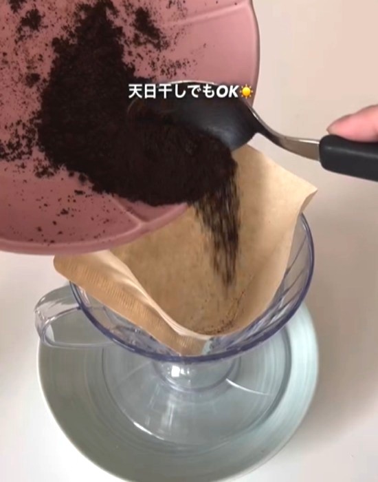 コーヒーフィルターに加熱したコーヒーグラウンズを入れる様子