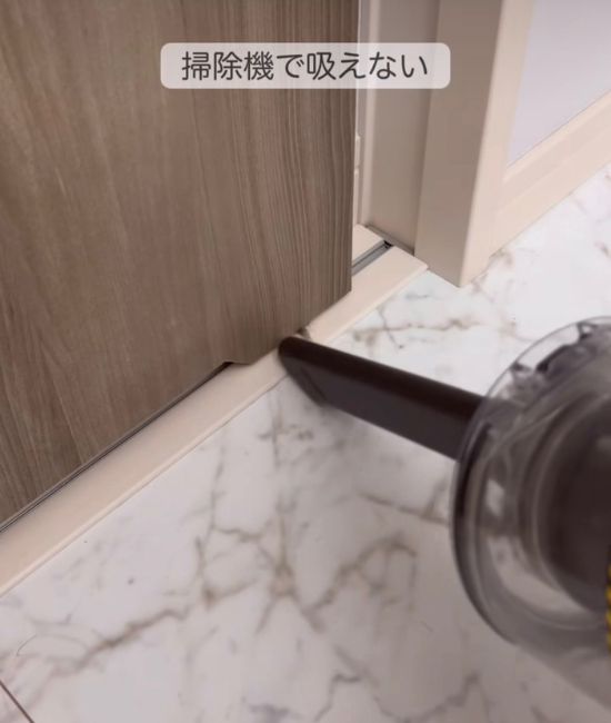 ドアレールに掃除機をかける様子