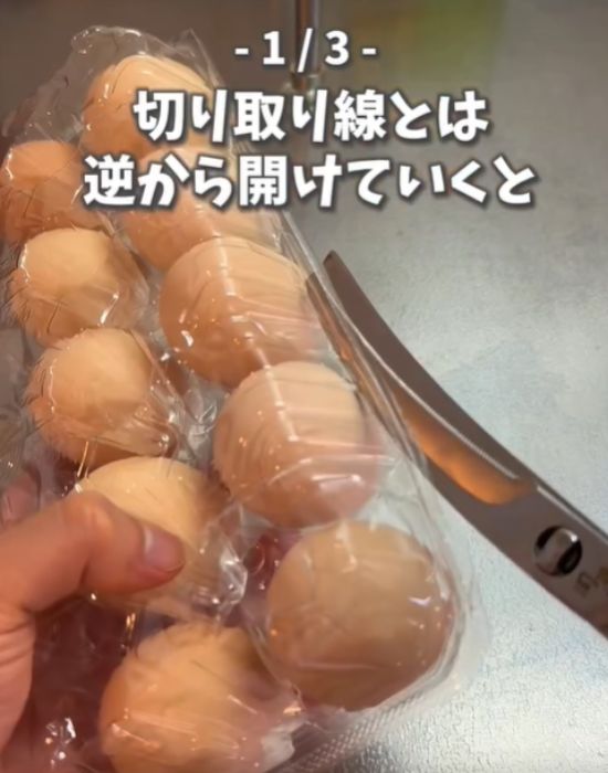 卵パックの切り取り線の逆側をハサミでカットする様子
