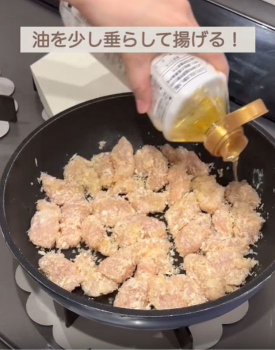フライパンに並べた肉の上から油を垂らす様子