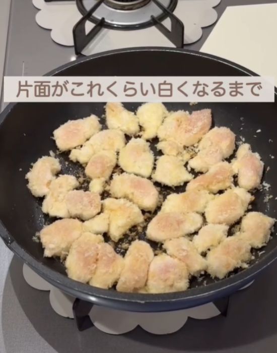 フライパンでパン粉をまぶした肉を焼く様子