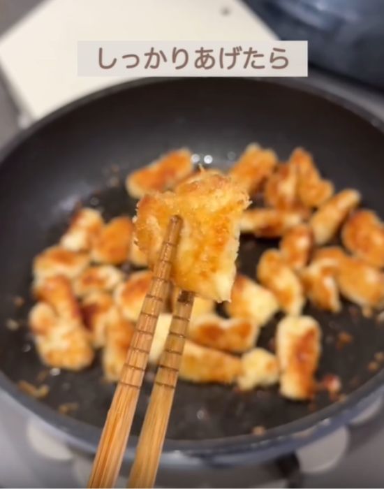 揚げた肉を箸で取る様子