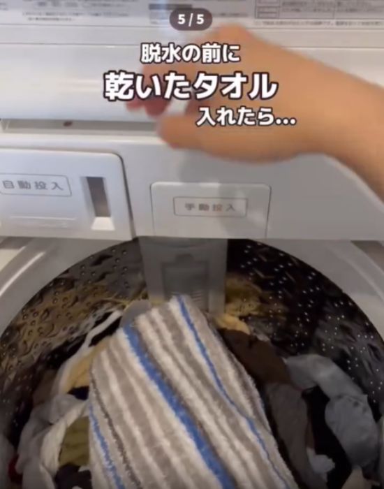 洗濯機にバスタオルを入れる様子