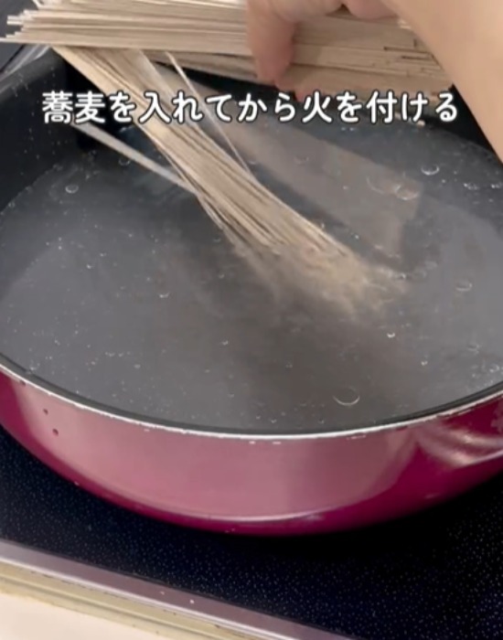 水の入ったフライパンにそばを入れる様子