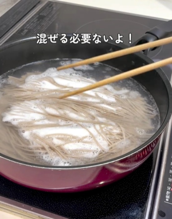 フライパンでそばをゆでる様子