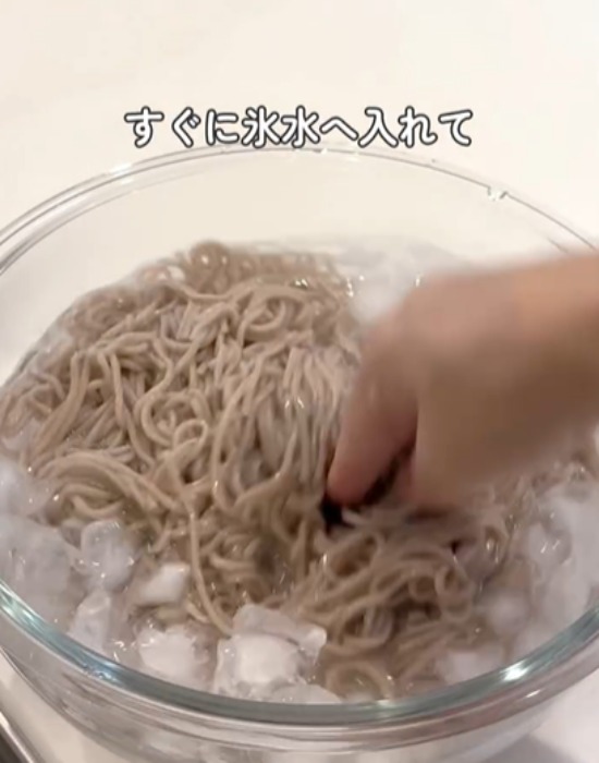 そばを氷水の入ったボウルに入れる様子