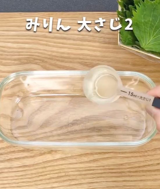 耐熱容器に計量スプーンでみりんを入れる様子