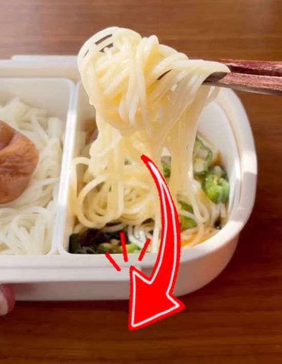 めんつゆをかけたそうめんを箸で持ち上げている様子
