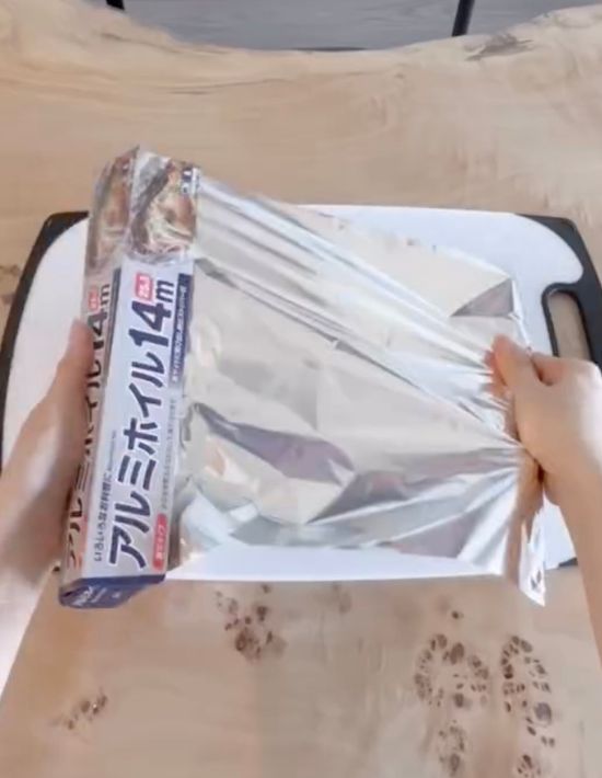 まな板の上にアルミホイルを広げる様子