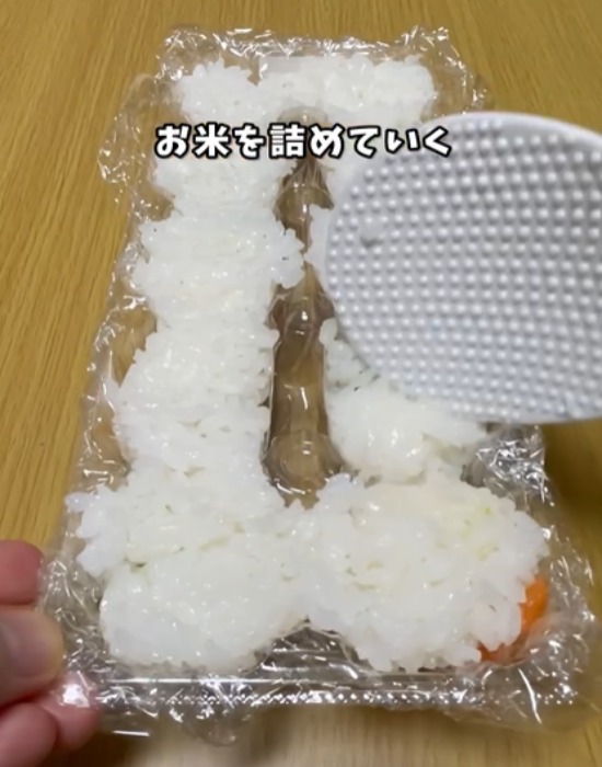 ラップの上からお米を詰める様子