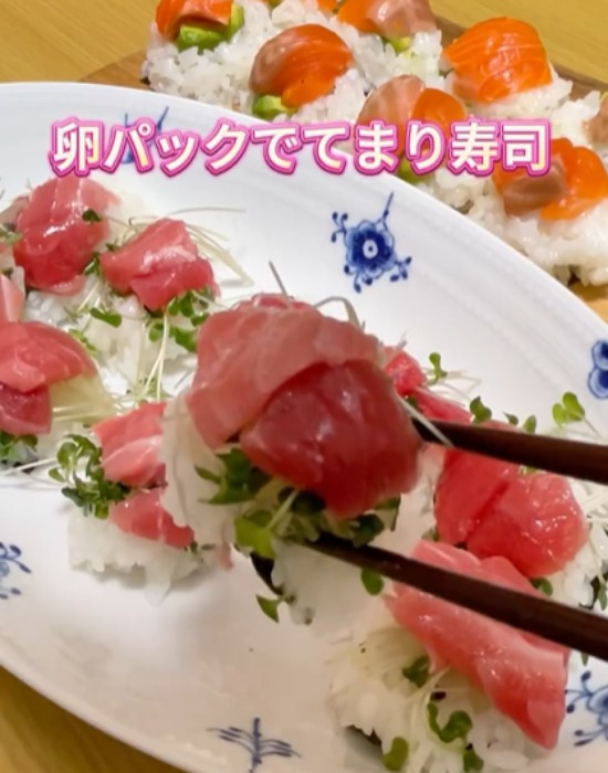お皿に盛り付けたてまり寿司を箸で取る様子