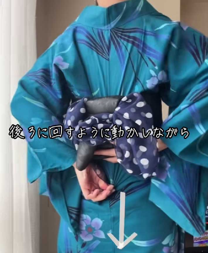 両肩を回しながら背中側の布を下に引く