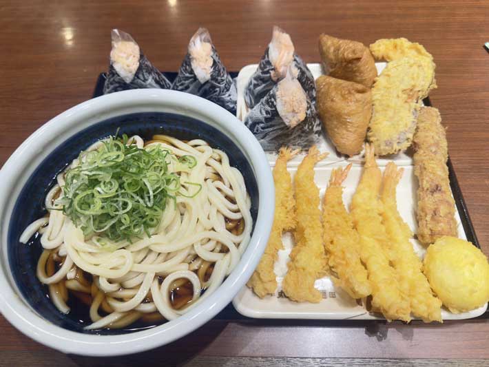 うどんのほか、天ぷら、おにぎり、いなり寿司がのせられた盆